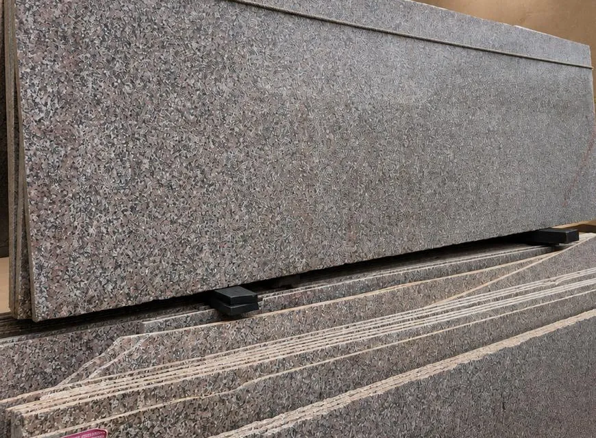 Cheema granite: a fine rose-brown and grey speckled polished slab face, from a stack in the showroom
