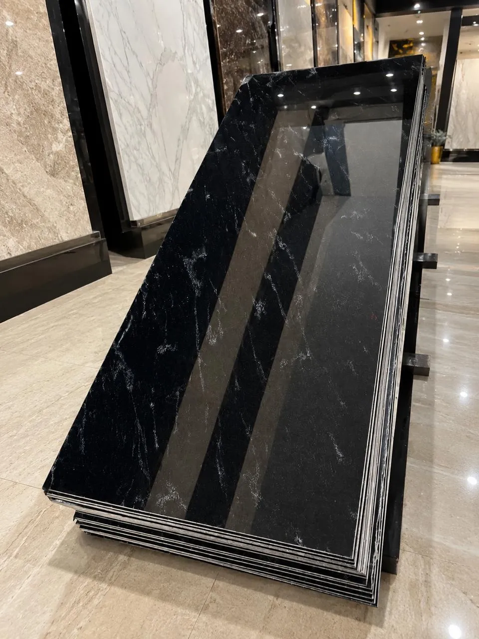 Fish Black granite: a stack of polished black slabs crossed by fine silver-white threads, photographed in the showroom