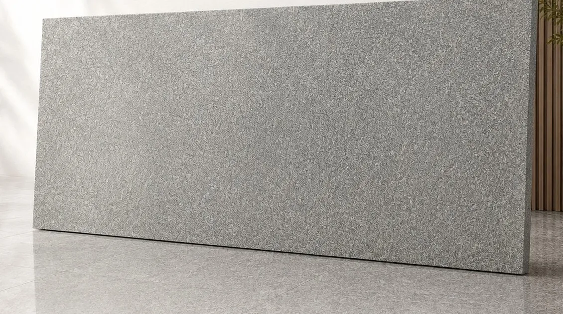 Sheera Grey granite: an even silver-grey surface with a fine, densely packed mineral grain, polished to a soft sheen